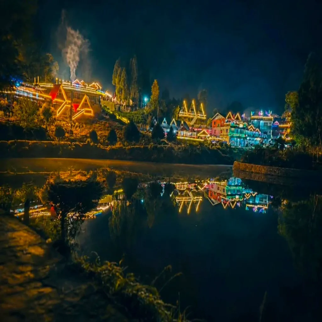 Night view of Antu Pokhari with reflections of lights on the lake
